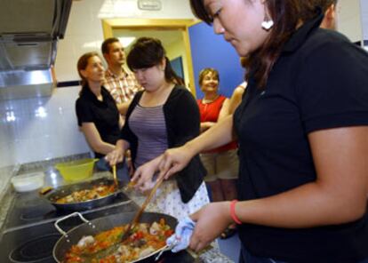 Un grupo de estudiantes aprendía ayer a cocinar paella.