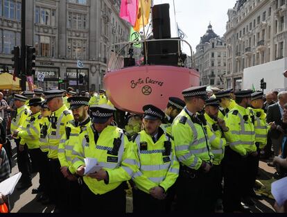 Extinction Rebellion (XR), un movimiento que se ha vuelto internacional defiende en Reino Unido la proclamación de un 'estado de emergencia climática y ecológica', la elaboración de un plan de acciones para 'reducir a cero' las emisiones netas de gases con efecto invernadero y la creación de una 'asamblea ciudadana' que, con la colaboración de expertos, participe en todo lo que afecta al clima. En la imagen, las fuerzas policiales rodean un bote en Oxford Circus en Londres, el viernes 19 de abril de 2019.