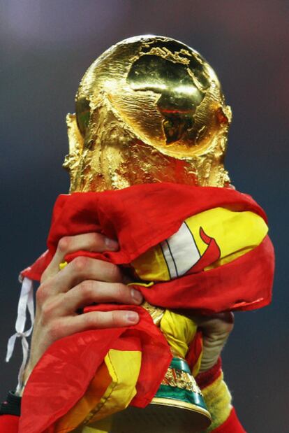 La Copa del Mundo envuelta en una bandera española.