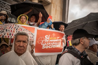 Asistentes a la marcha sostienen carteles con consignas en apoyo a las reformas.