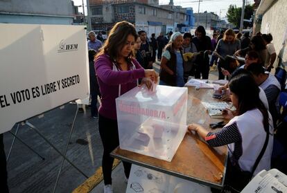 Una mujer emite su voto para gobernador del Estado de México en una mesa de votación en Nezahualcoyotl