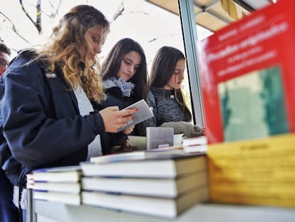 Tres j&oacute;venes en una caseta de la Fira del Llibre de Valencia. 