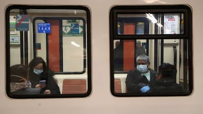 Usuarios protegidos con mascarillas en el interior de un vagón del Metro de Madrid.