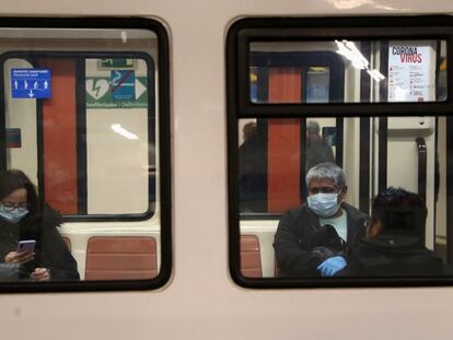 Usuarios protegidos con mascarillas en el interior de un vagón del Metro de Madrid.