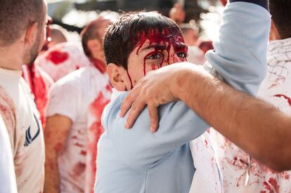 Cada vez más niños  se golpean con las manos la brecha en la cabeza para hacer brotar la sangre mientras sus padres y madres les incitan al grito de ¡Haidar!. La sangre resbala por las frentes y rostros de los jóvenes y no tan jóvenes para poco a poco teñir de un rojo vivo las ropas blancas, sus manos y finalmente las calles a su paso.