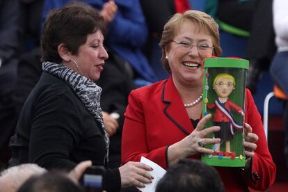 La Presidenta de Chile, Michelle Bachelet (d), recibe un obsequio, durante una actividad en la comuna de El Bosque en Santiago de Chile.