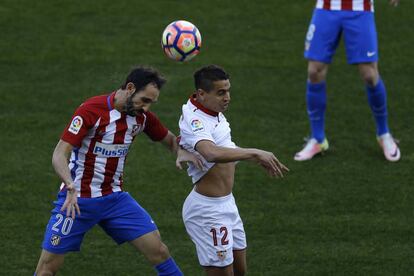 Juan Francisco Torres "Juanfran", del Atletico de Madrid, pelea por el balón contra el jugador del Sevilla Ben Yedder.