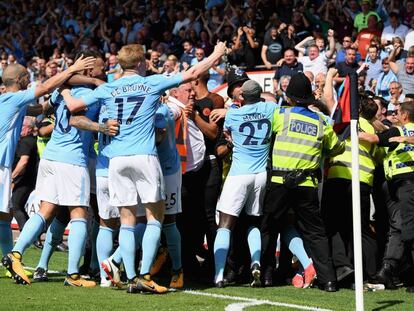 Los jugadores del City celebran entre la afición y la policía.