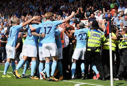 Los jugadores del City celebran entre la afición y la policía.