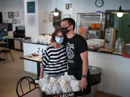 Paloma de Diego y Jaime Rincón se dan un abrazo en Casa Carmela, restaurante que reparte menús solidarios de comidas.