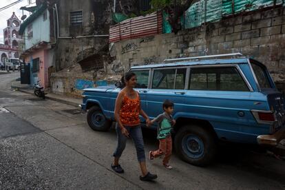 Alice Ortiz camina junto a su bisnieto Ender en el barrio de Petare en Caracas.