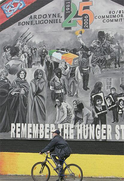 Un niño pasa en bicicleta por delante de un mural republicano irlandés en el norte de Belast.