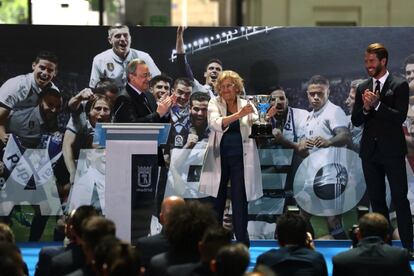 La alcaldesa de Madrid Manuela Carmena muestra una réplica del trofeo de liga, junto al presidente del Real Madrid Florentino Pérez y el jugador, Sergio Ramos.