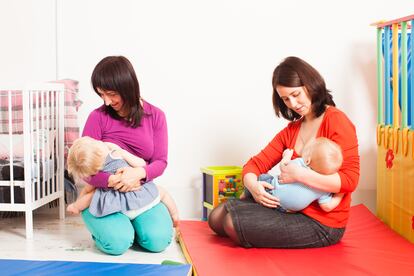 Dos madres dan el pecho a sus hijos.