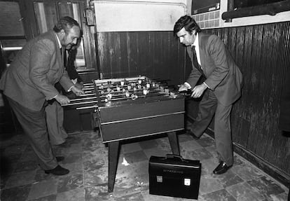 El ministro de Sanidad y Consumo, Ernest Lluch (a la derecha), jugaba al futbolín con un colaborador en un restaurante de Madrid tras la reunión del Consejo de Ministros, el 2 de febrero de 1983. En el suelo, el maletín de ministro.