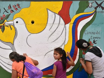 Dos colombianas pintan un mural por la paz.