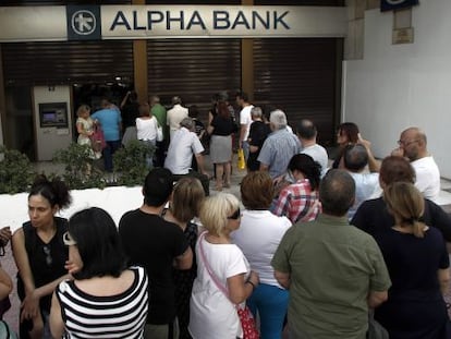 Atenienses fazem fila em frente a um caixa.