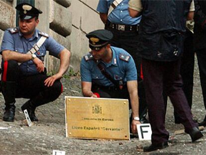 Varios carabineros italianos inspeccionan el lugar donde estalló la bomba contra el liceo español en Roma.