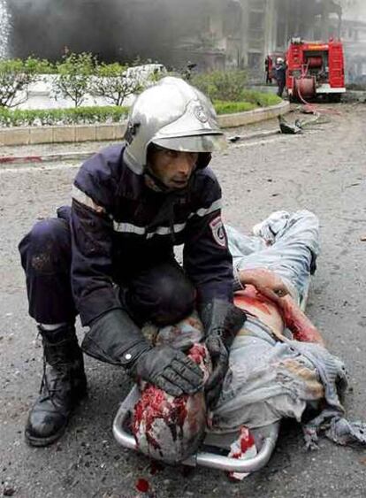 Un bombero cubre el rostro de uno de los heridos en el atentado de ayer contra la sede del Gobierno en Argel.