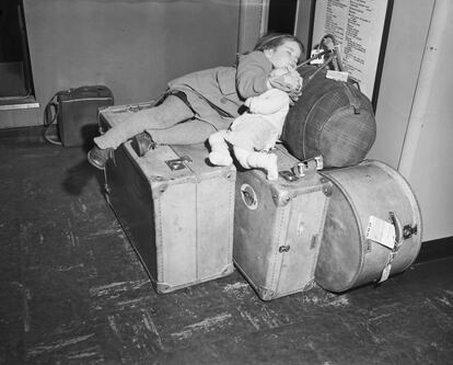 Un niño descansa sobre unas maletas en un aeropuerto californiano en 1950.