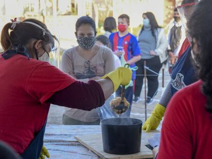 Un grupo de mujeres reparte comida en el merendero de las tacitas poderosas, en Buenos Aires (Argentina).