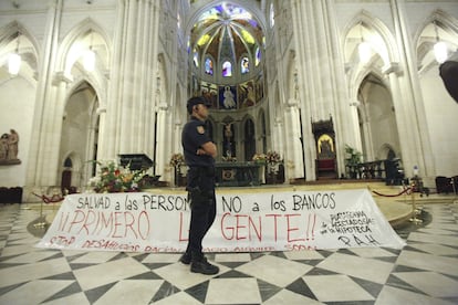 Un agente, ante la pancarta colocada por los manifestantes en el interior del templo.