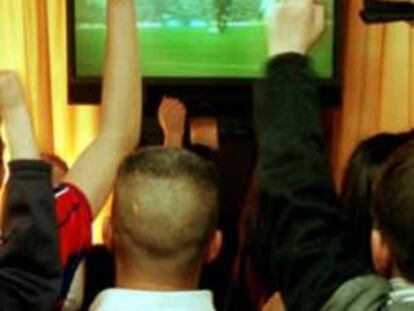 Gente viendo un partido de fútbol en un bar