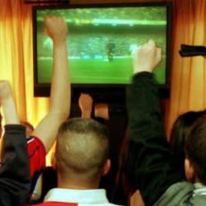 Gente viendo un partido de fútbol en un bar