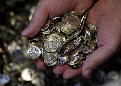Un empleado de la Casa de la Moneda sostiene monedas de un euro. 