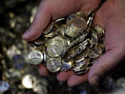 Un empleado de la Casa de la Moneda sostiene monedas de un euro.