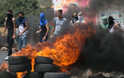 Manifestantes palestinos hacen barricadas durante las protestas en el control de Hawara, en Cisjordania.