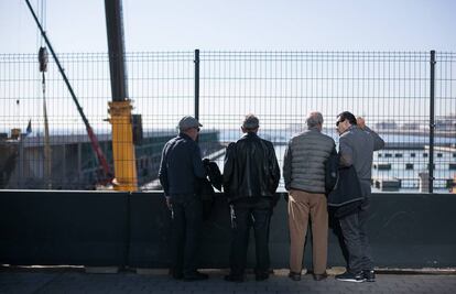 Un grup d'homes a Barcelona observa l'evolució d'unes obres.