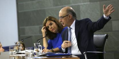 La vicepresidenta del Gobierno, Soraya Sáenz de Santamaría (i), y el ministro de Hacienda, Cristóbal Montoro, durante la rueda de prensa posterior al Consejo de Ministros de este viernes.