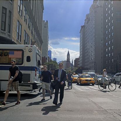 La diversidad de Nueva York en el barrio de Chelsea (en la Octava Avenida con la calle 23). Al fondo, la Torre de la Libertad (donde se levantaban las Torres Gemelas). En primer plano, la nueva locura de las bicis y hombres con su móvil o con un bote de proteínas en polvo.