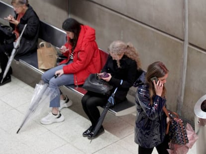 Unas mujeres usan sus móviles en el metro.