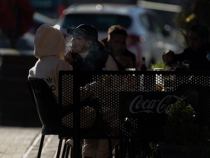 Una persona, fumando en una terraza en Madrid.