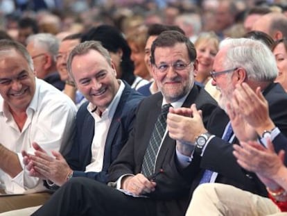 El presidente del Gobierno, Mariano Rajoy, entre Arias Cañete y Alberto Fabra en el mitin de Valencia.