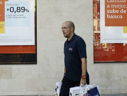 Un hombre pasa por delante de la publicidad de hipotecas de una sucursal bancaria, en Madrid.