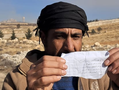 A man shows a piece of paper with the names of his imprisoned relatives.