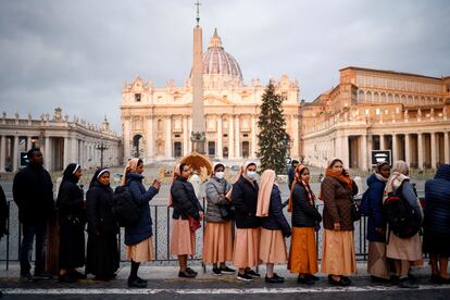 Varias religiosas esperan para rendir homenaje al papa emérito en la plaza de San Pedro.