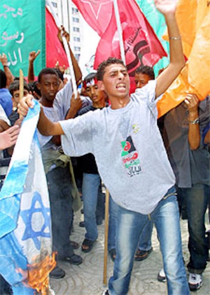 Manifestantes palestinos queman una bandera de Israel ayer en Gaza.