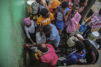 Personas afectadas por el terremoto de 7,2 grados del sábado recogen agua después de dormir en las calles de Les Cayes, este domingo. 