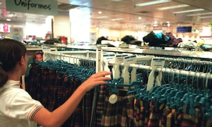 Una ni&ntilde;a mira uniformes escolares en un centro comercial de Madrid.