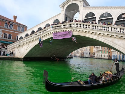 People ride in boats as waters of Grand Canal turned green after a protest by 'Extinction Rebellion' climate activists in Venice, Italy, December 9, 2023. REUTERS/Manuel Silvestri