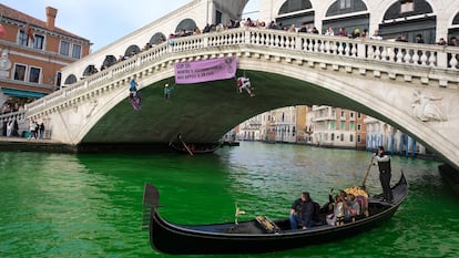 People ride in boats as waters of Grand Canal turned green after a protest by 'Extinction Rebellion' climate activists in Venice, Italy, December 9, 2023. REUTERS/Manuel Silvestri