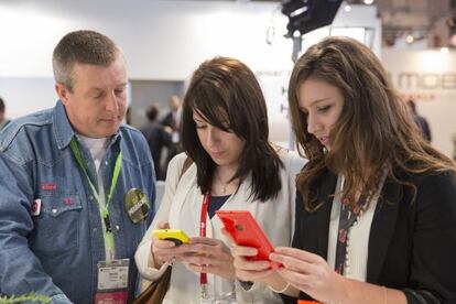 Duas mulheres verificam celulares no Mobile World Congress.