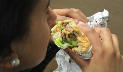 Una persona comiendo un &quot;burgrito&quot;, una combinaci&oacute;n de burrito mexicano y hamburguesa.