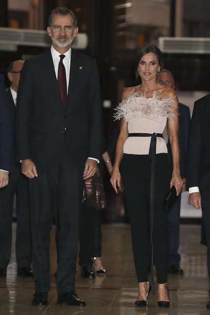 Este 2019, los Reyes han acudido a los premios Princesa de Asturias acompañados por primera vez de sus hijas, la princesa Leonor y la infanta Sofía. Tras la bienvenida de los cuatro en Oviedo, don Felipe y doña Letizia han presidido ya sin la presencia de sus hijas el XXVIII Concierto Premios Princesa de Asturias en el auditorio Príncipe Felipe. Para esta ocasión, la Reina ha elegido un conjunto de la firma The 2nd Skin Co formado por top beige con escote palabra de honor y plumas con pantalón y un maxi cinutón a juego. 