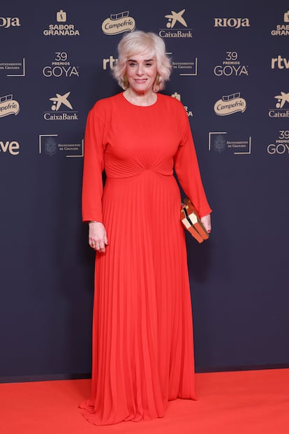 Anabel Alonso, con un vestido rojo de falda plisada de Mirto para Es Fascinante y joyas y bolso de Fahoma.