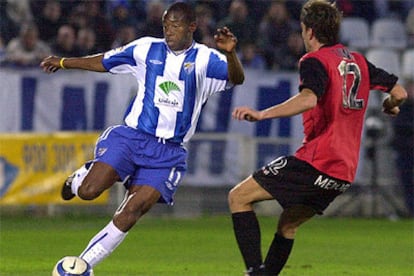 El delantero del Málaga Paulo César Wanchope trata de llevarse el balón ante la oposición de Antoni Lluis Adrover.